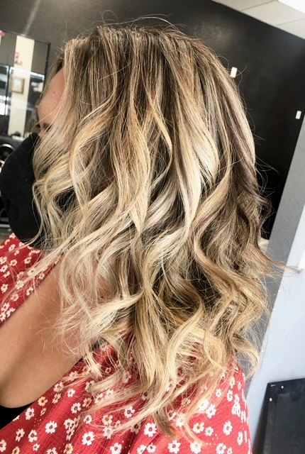 Long blonde balayage curled into loose waves
